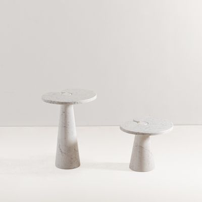 deux tabourets en béton posés sur un sol blanc