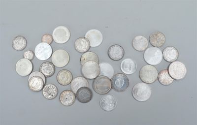 plusieurs types différents de pièces d'argent sur une surface grise