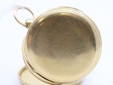 a close up of a gold pocket watch on a white surface
