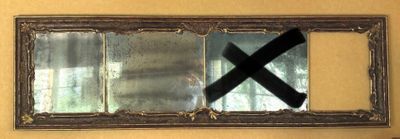 a reflection of a person in a mirror with a black cross on it