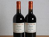 deux bouteilles de vin posées sur une table en bois, à côté d'une bouteille de vin