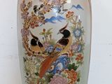 a vase with a bird on it sitting on a table