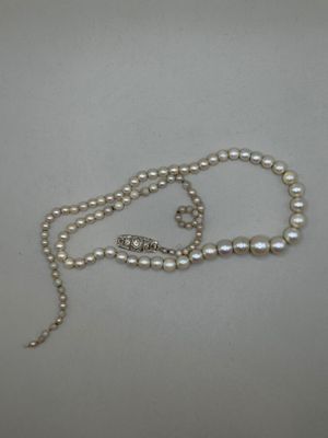 gros plan d'un collier de perles sur une surface blanche