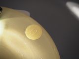 a close up of a gold vase with a gold label on it
