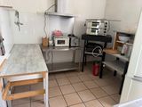 a kitchen with a stove, microwave, and a table in it