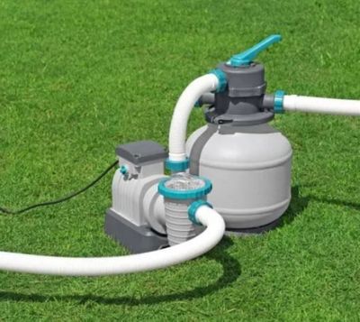 une pompe à eau raccordée à un tuyau d'arrosage sur la pelouse