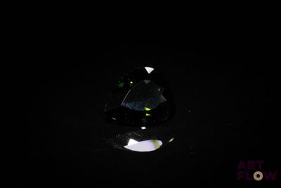 un gros plan d'un diamant noir sur une surface noire