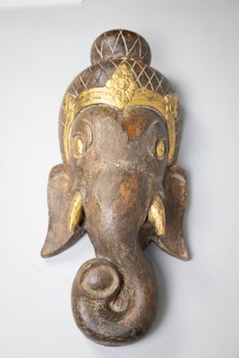 an elephant head hanging on the wall of a room