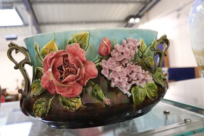 un vase orné de fleurs peintes, posé sur une table en verre