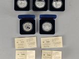 a group of six silver coins in boxes with labels on them
