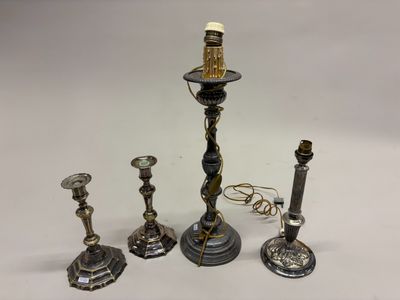 trois bougeoirs en argent et un porte-bougie sur fond blanc