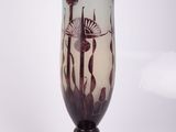 un vase en verre avec un tableau posé sur une table