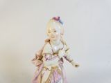 a figurine of a little girl in a pink dress