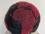 a black ball with red dots on it sitting on a table
