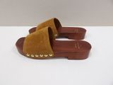a close up of a pair of brown sandals on a white surface