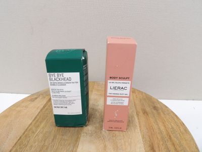 a bottle of blackhead and a tube of blackhead on a wooden table