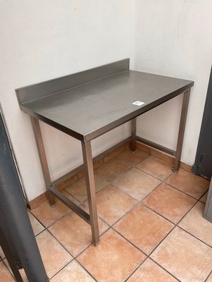 a table with a metal top in the corner of a room