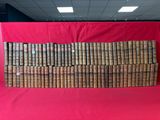 une grande pile de vieux livres posée sur un tissu rouge