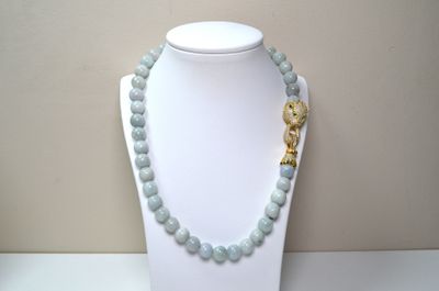 beaded necklace with a gold elephant charm on a white mannequin