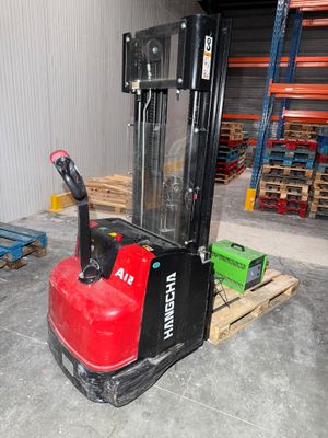 a red fork lift truck in a warehouse with pallets