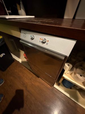 une personne debout devant un lave-vaisselle dans une cuisine