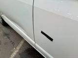 a white car parked in a parking lot with its door open