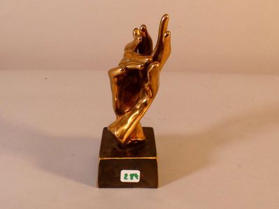 une statue en or représentant une personne tenant une raquette de tennis