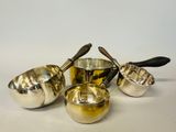 four pieces of silverware sitting on top of a white surface