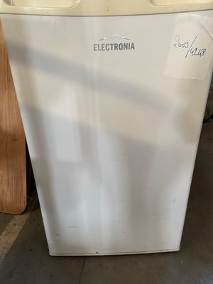a white refrigerator sitting on the floor in a room