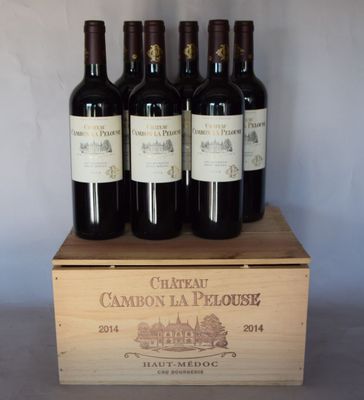 quatre bouteilles de vin rouge dans un coffret en bois posé sur une table