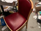 a red chair that is sitting in the middle of a cluttered room