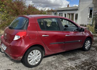 a small red car parked in front of a house