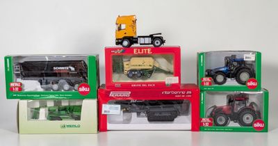four different models of tractors in boxes on a table