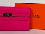 a pink and orange hermeson wallet next to an orange box