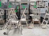 de nombreuses chaises et échelles dans un grand entrepôt