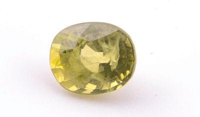 gros plan d'une pierre de saphir jaune sur une surface blanche
