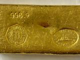 gros plan d'un lingot d'or sur une surface blanche