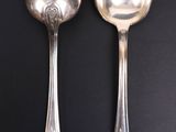 two spoons and a spoon on a black surface