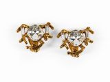 a pair of gold tone earrings with a heart shaped crystal