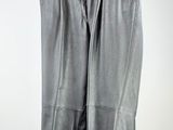 black leather pants hanging on a hanger against a white wall
