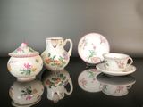 trois théières et deux tasses posées sur une table
