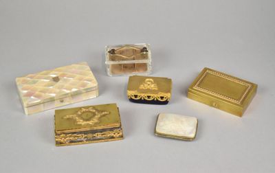 four small gold and mother of pearl boxes on a white surface