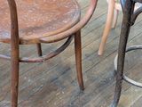 two wooden chairs and a table on a wooden floor