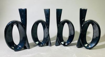trois vases noirs posés les uns à côté des autres sur une table