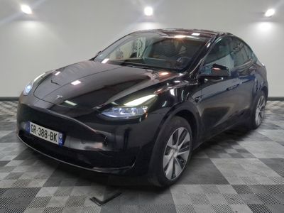 une image représentant une voiture électrique noire sur un sol à damier
