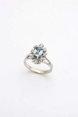a white gold ring with a blue topaz stone surrounded by diamonds