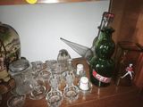 bottles and glasses on a wooden shelf in a room