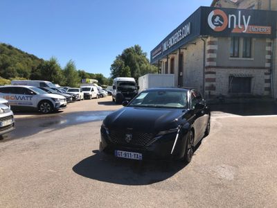 a black car parked in front of a building in a parking lot