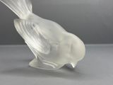 a glass bird that is sitting on a table