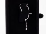 a black box with a white diamond necklace inside of it